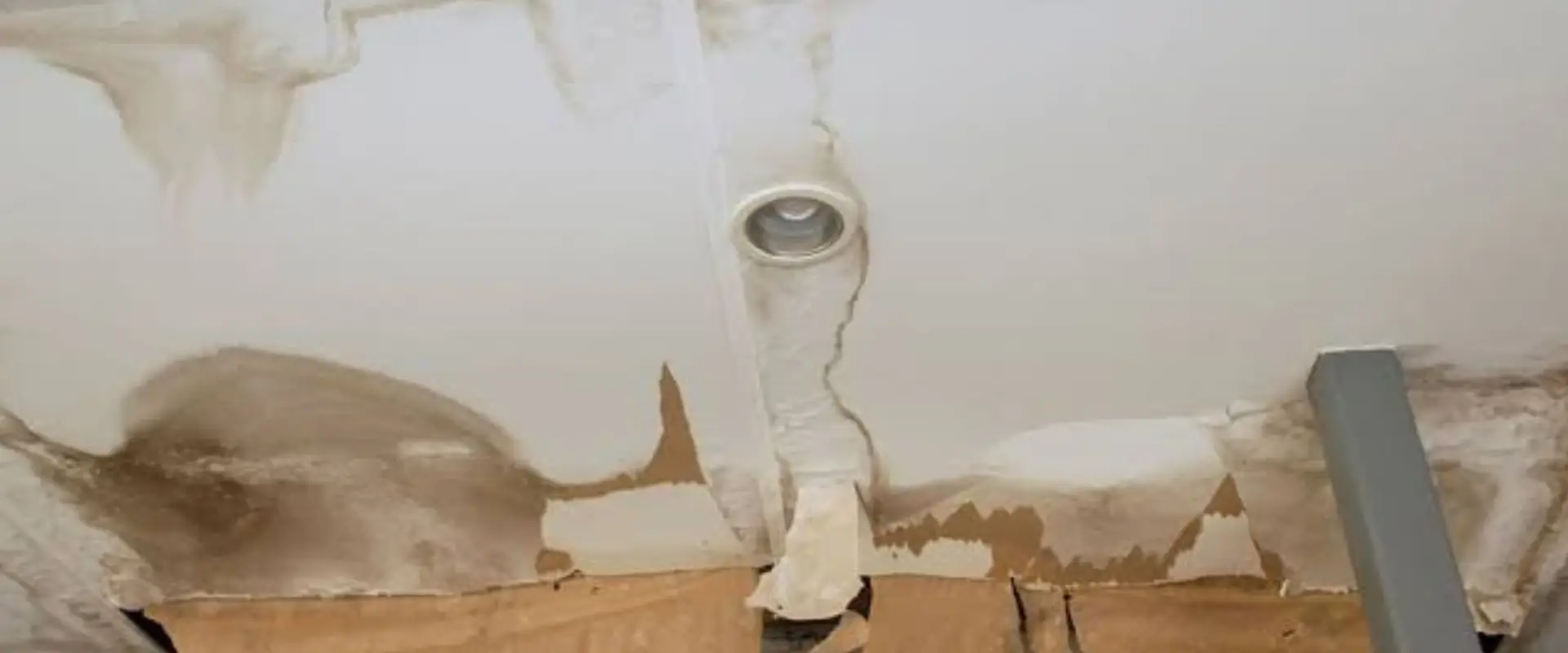 Water-stained ceiling with peeling paint around a light fixture